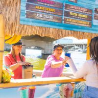 Maui Wowi employee handing customer a smoothie